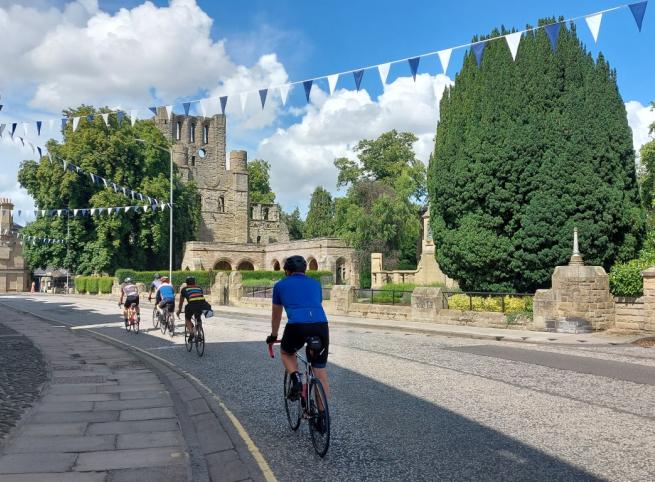 Cycling past Kelso Abbey