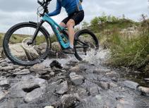 Biker splashing through river