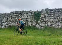 Biker riding by stone wall
