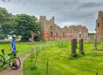 Biker visiting ruins and graveyard